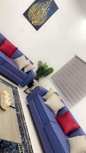 努瓦克肖特Best Residence的客厅配有蓝色沙发和红色枕头