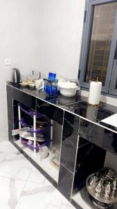 努瓦克肖特Best Residence的厨房配有带餐具的黑色台面
