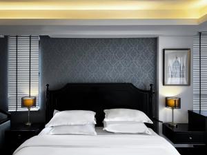 清迈Glory Boutique Suites 清迈古城荣耀精品酒店的一间卧室配有一张大床和两盏灯