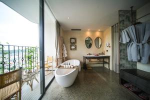 归仁L'amor Boutique Hotel Quy Nhơn的带浴缸的浴室和阳台
