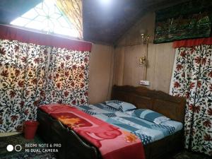 斯利那加The Hotel "Shafeeq" Across jawahar bridge的一间带床的卧室,位于带窗帘的房间