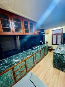 加德满都Hotel Bodhiz的厨房配有绿色大理石台面和木制橱柜