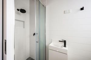 布赖特明亮小屋公园酒店的一间带水槽和玻璃淋浴的浴室