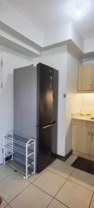 达沃市Modern 2BR Condo with Fiber Net的一间厨房,里面配有黑色冰箱