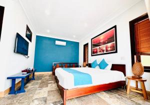 会安会安休闲花园精品别墅酒店的一间卧室设有一张大床和蓝色的墙壁