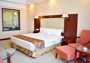 贡布Ha Tien Vegas Entertainment and Resort的配有一张床和一把椅子的酒店客房