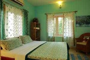 阿勒皮Bella Homestay Kerala的一间卧室配有一张蓝色墙壁和窗户的床