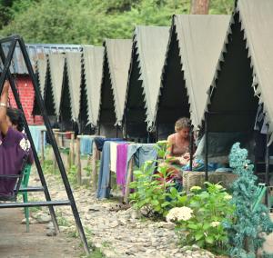 卡索尔Himtrek Riverside Camps, Kasol的坐在黑帐篷里的女人,坐在花园里的女人