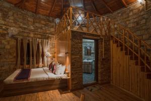 奈尼塔尔The Nature's Green Resort, Bhimtal, Nainital的一间卧室设有一张床和木制楼梯。
