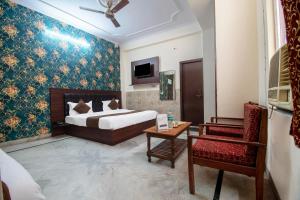 斋浦尔Hotel Marwal的配有一张床和一把椅子的酒店客房