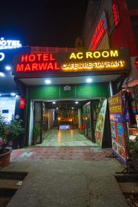 斋浦尔Hotel Marwal的一座带酒店标志的建筑和一座房间