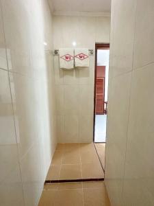 SibolgaHotel Wisata Indah Sibolga的带淋浴的浴室和墙上的2条毛巾