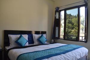 ChaukoriAtithi Home Stay - Himalayas view的一间卧室设有一张大床和大窗户