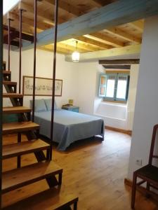 Villanueva del Conde巴图尔卡斯乡村小屋酒店的一间带一张床的卧室,位于带木制天花板的房间内