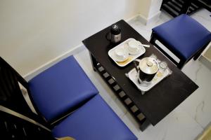 ChaukoriAtithi Home Stay - Himalayas view的一张桌子,两把蓝色的椅子和一个带杯子和咖啡的托盘