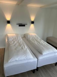 芬斯内斯Finsnes Gaard的配有两盏灯的房间的一张白色床