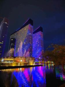 巴统Orbi City Luxury Tower的一座蓝色和紫色灯的大建筑