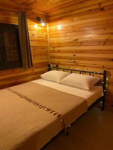 ArdeşenRitiny House的木制客房内的一间卧室,配有一张床