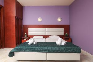 贝尼蔡斯Kerkyra Beach Hotel & Apartments的一间卧室设有一张紫色墙壁的大床