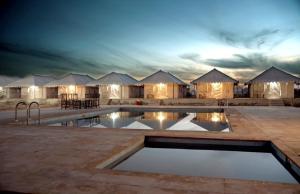 斋沙默尔Jaisalmer best desert Safari Camp的一组帐篷前的带游泳池的酒店