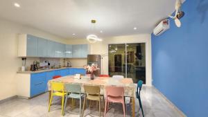 乔治市La Belle Maison 12 @ Gurney Kelawai/Pulau Tikus/Georgetown的厨房配有桌椅和蓝色橱柜。