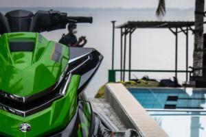 卡图纳耶克New saniro Lagoon Deck的停在游泳池旁的绿色摩托车