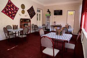 撒马尔罕World Guest House的一间带桌椅和电视的用餐室