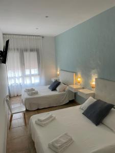 萨阿拉德洛斯阿图内斯El Escondido de Zahara的酒店客房,配有两张床和椅子