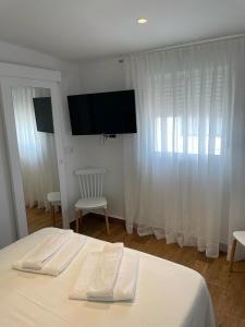 萨阿拉德洛斯阿图内斯El Escondido de Zahara的一间卧室配有一张带两条白色毛巾的床