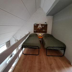 布勒伊尼瑟Appartement Bru Zeeland的阁楼间设有两张床和一张桌子