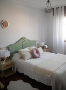 格罗韦Estrela de mar的一间卧室配有一张带紫色枕头的床