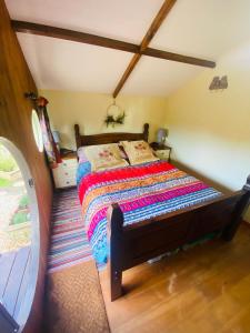 Praze an BeebleTyluna Cornish Cabin的一间卧室配有一张带五颜六色被子的床