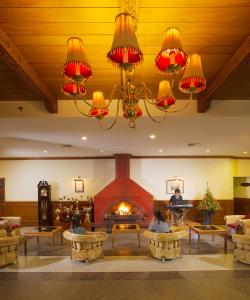 乌提宝石公园乌蒂酒店的大堂设有壁炉,客人可以躺在桌子上