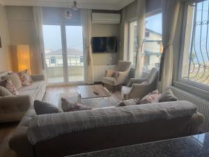亚洛瓦Yalova Apartments的客厅配有沙发、椅子和电视