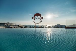 班邦森(1)Blu Monkey Hub and Hotel Bangsaen的水中一根杆上的猴子标志