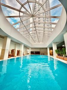 斯科普里Skopje Sky City 19th Floor Twin Apartments with Indoor Pool & Spa & Fitness Including in Price的一座拥有蓝色水面天花板的大型游泳池
