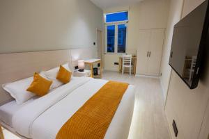 康格拉Luxury 3BHK Villa in Dharamshala with Jacuzzi的卧室配有带橙色枕头的大型白色床