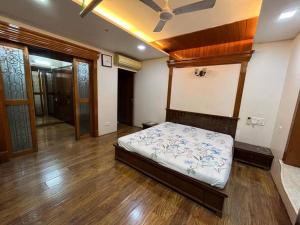 纳威孟买Luxury 4BHK Penthouse with Theatre, Jacuzzi & Private Terrace的铺有木地板的客房内设有一间卧室和一张床。