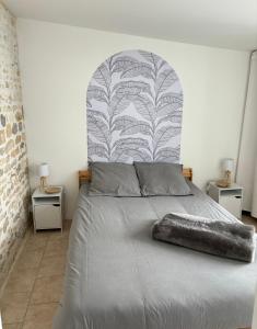 奥雷龙圣但尼Le Patio - Saint-Denis d’Oléron的一间卧室配有一张带大床头板的床
