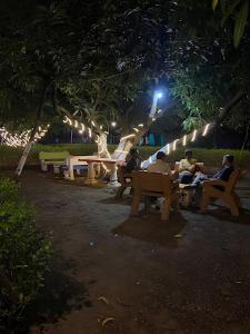 萨三吉尔Renewed Jadeshwar Farm Resort的那些晚上坐在公园长椅上的人