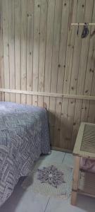 拉古纳Vista da lagoa的一间卧室设有一张床和木墙