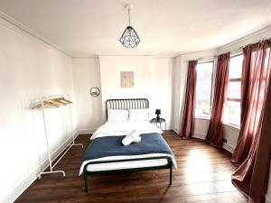 伦敦Charming, Renovated Residence in Willesden Green的一间卧室设有一张床和两个窗户。