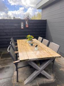 弗劳温普尔德Etoile aan Zee的庭院里配有一张带椅子和鲜花的木桌