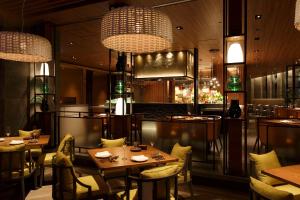 福冈福冈君悦大酒店的餐厅设有桌椅和吊灯。