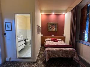 卢卡Villa San Donato B&B的一间带床和镜子的卧室以及一间浴室