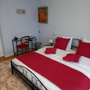 博韦Molibeau的一间卧室配有一张带红色枕头的大床
