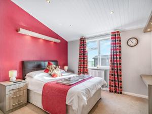 LochwinnochOakwood Lodge的一间卧室设有红色的墙壁、一张床和一个时钟
