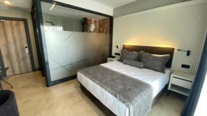 居吕克ROSEIRA MAR-INN LUXURY的一间卧室设有一张大床和一个大镜子