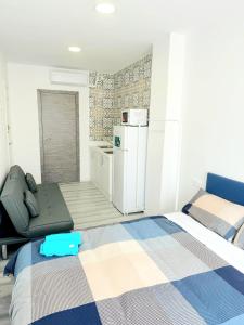 马尼塞斯Apartamentos Aeropuerto Valencia的小房间设有两张床和一台冰箱