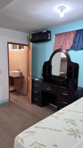 玉米岛The Wave Hostel Corn Island的卧室配有带镜子和水槽的梳妆台